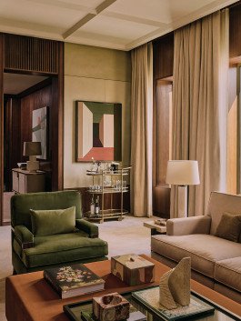 Living room featuring a green velvet armchair, abstract art, and a stylish bar cart, Kensington Leverne Photography. 